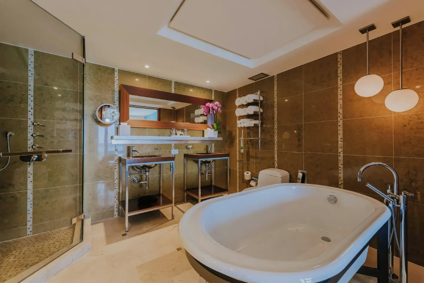 Large bathroom with soaking tub and glass shower at Renaissance Wind Creek Aruba Resort.