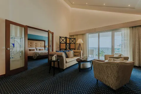 Suite living room with balcony and bedroom at Renaissance Wind Creek Aruba Resort.