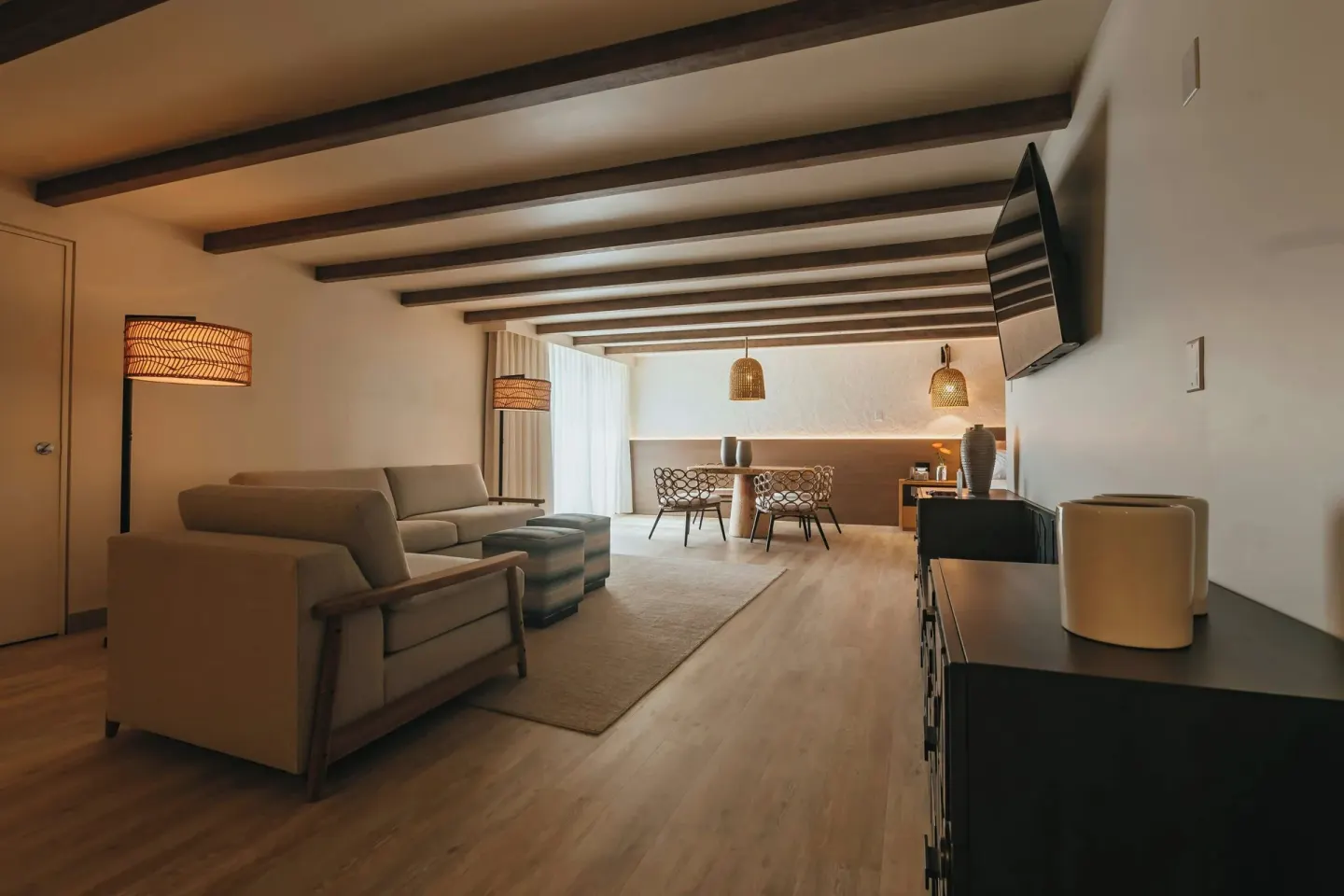 Suite lounge with dining table and wall-mounted TV at Renaissance Wind Creek Aruba Resort.