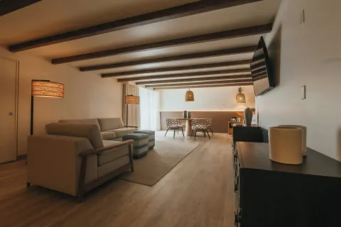 Suite lounge with dining table and wall-mounted TV at Renaissance Wind Creek Aruba Resort.