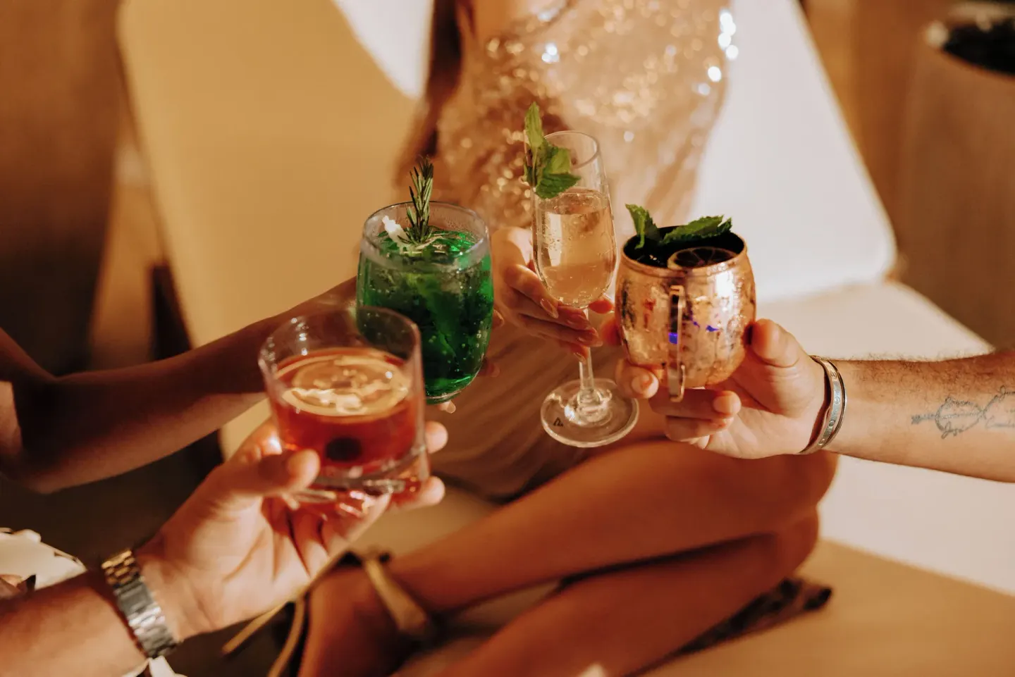 Guests raising cocktails in a lounge setting at Renaissance Wind Creek Aruba Resort.