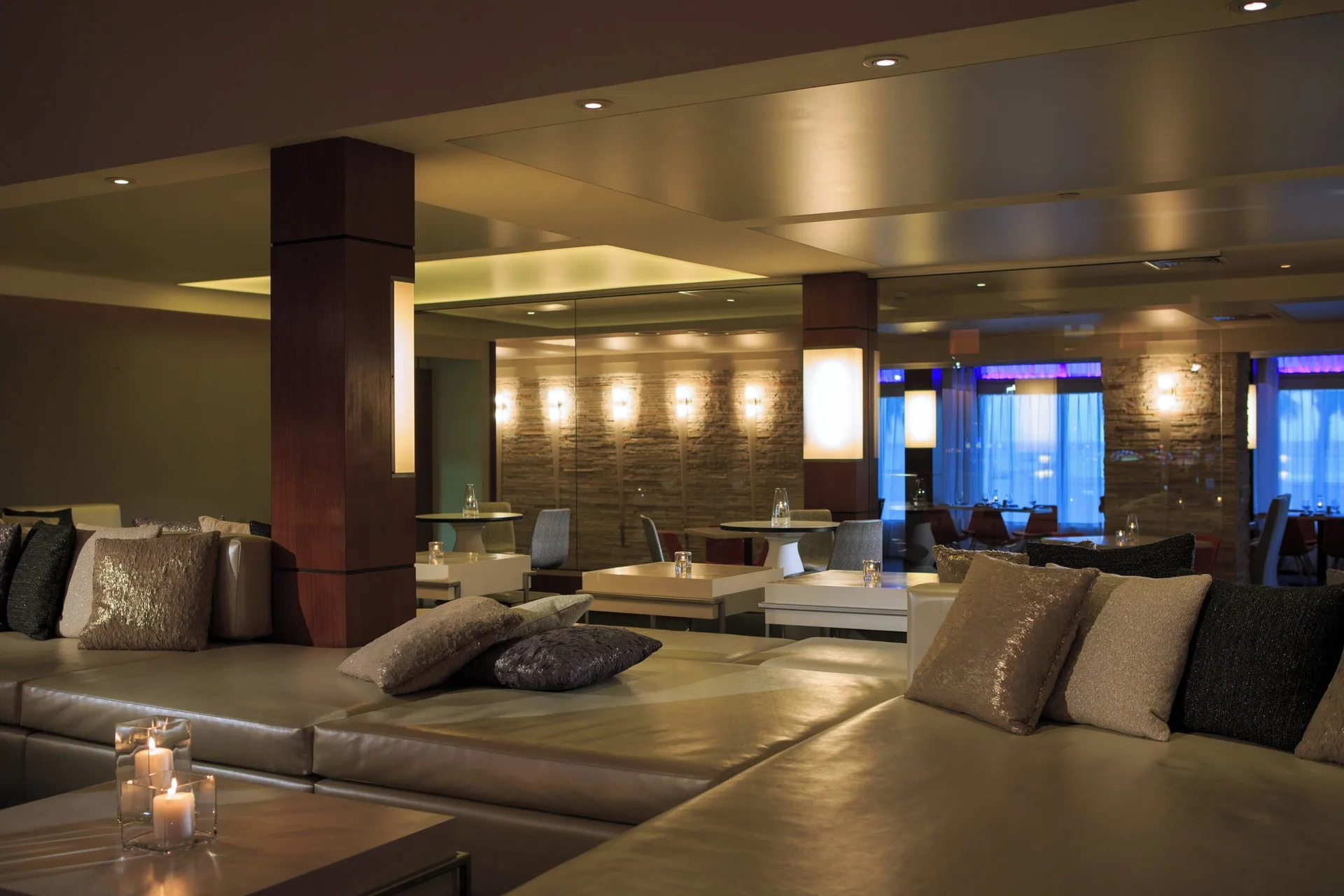 Modern lounge seating with pillows and candlelight at Renaissance Wind Creek Aruba Resort.