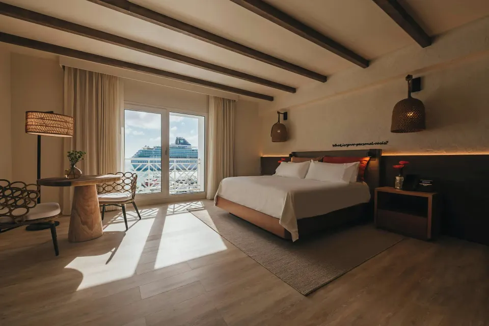 Executive Suite king bed with balcony view at Renaissance Wind Creek Aruba Resort.