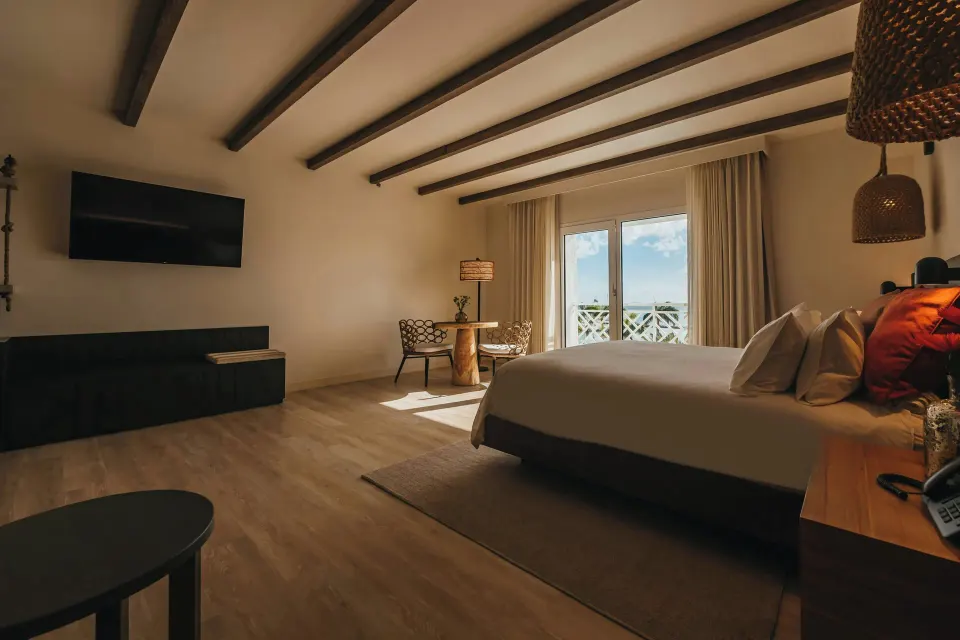 Executive Suite king bed and wall-mounted TV at Renaissance Wind Creek Aruba Resort.