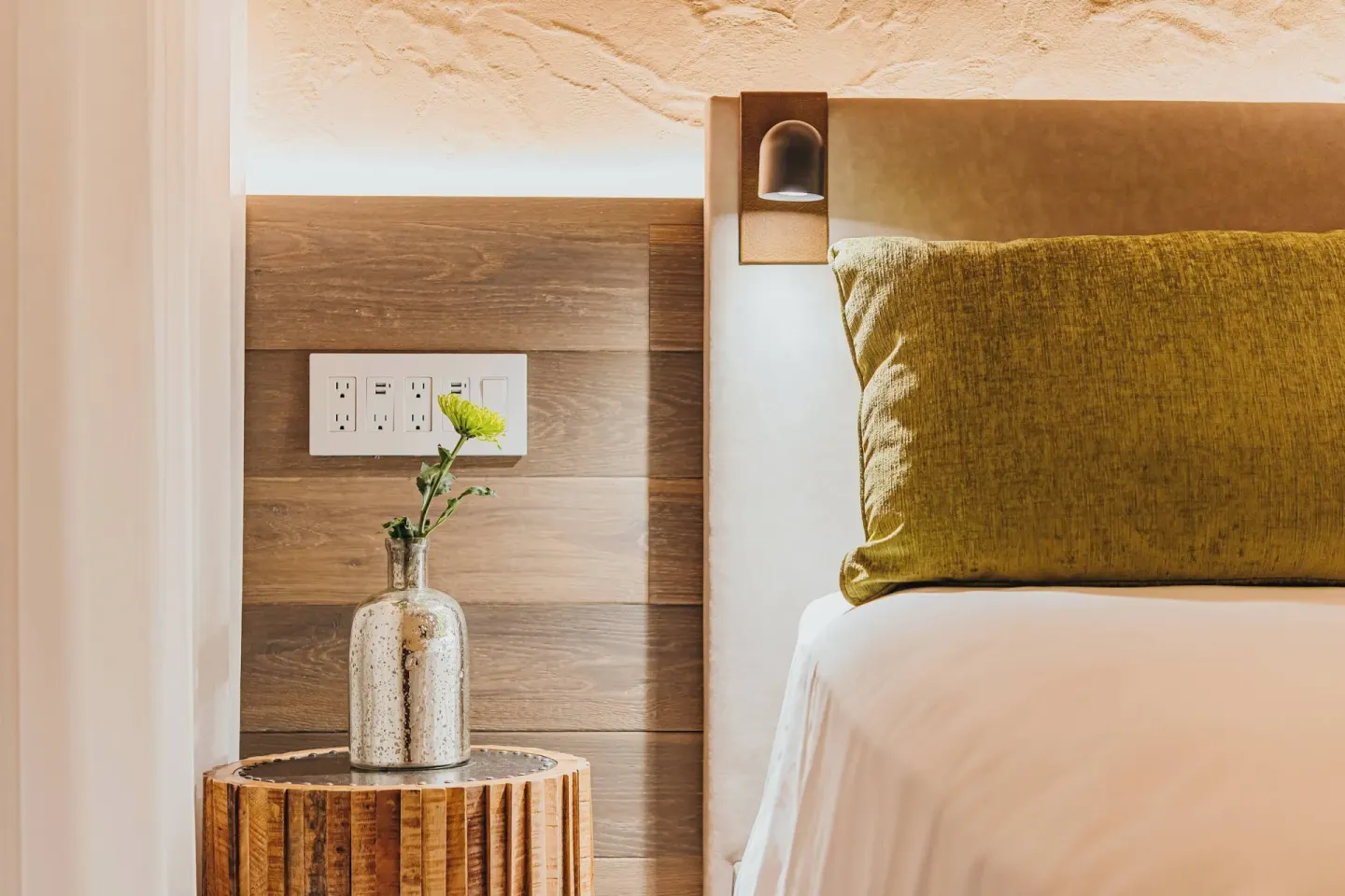 Guest room bedside detail with pillow, lamp and flower vase at Renaissance Wind Creek Aruba Resort.