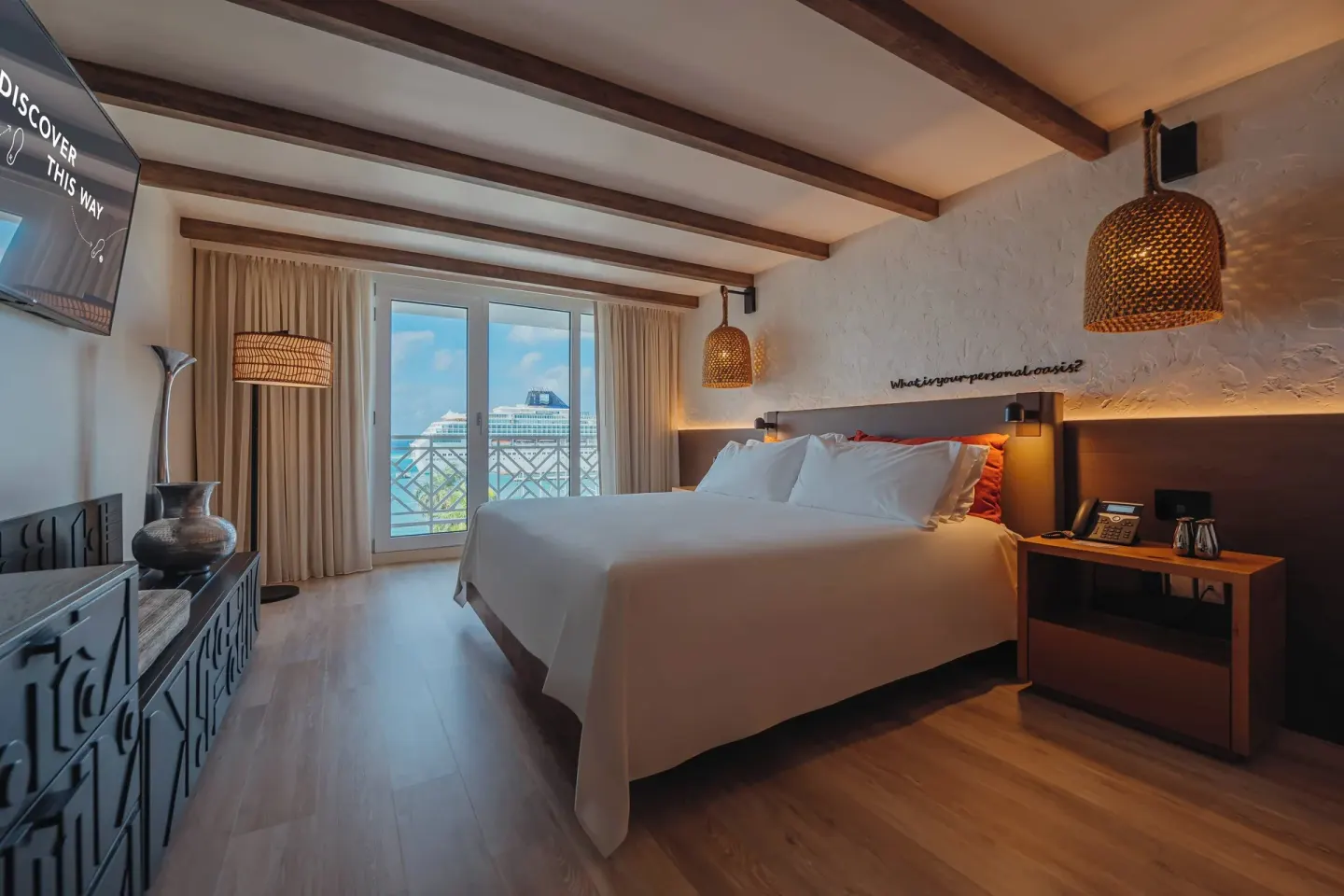 Ocean View room with a king bed and balcony doors at Renaissance Wind Creek Aruba Resort.