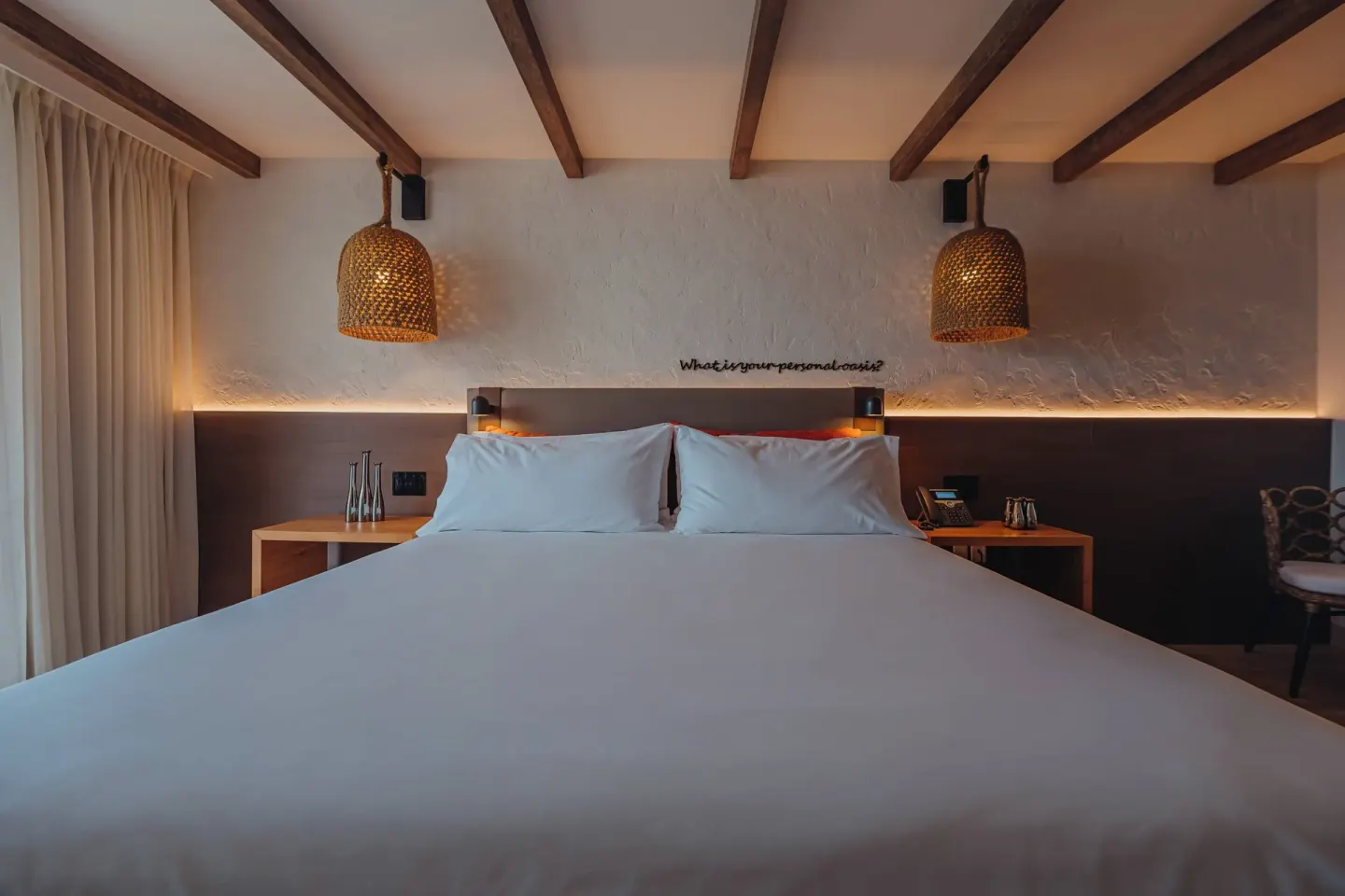 King bed with woven pendant lights in an Ocean View room at Renaissance Wind Creek Aruba Resort.