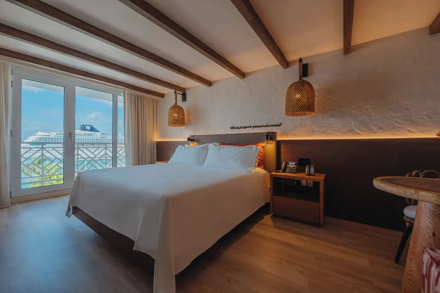 Ocean View room with king bed, balcony doors, and small table at Renaissance Wind Creek Aruba Resort.