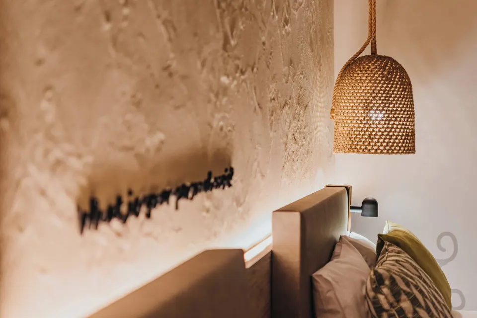 Bedside wall texture and woven pendant light at Renaissance Wind Creek Aruba Resort.
