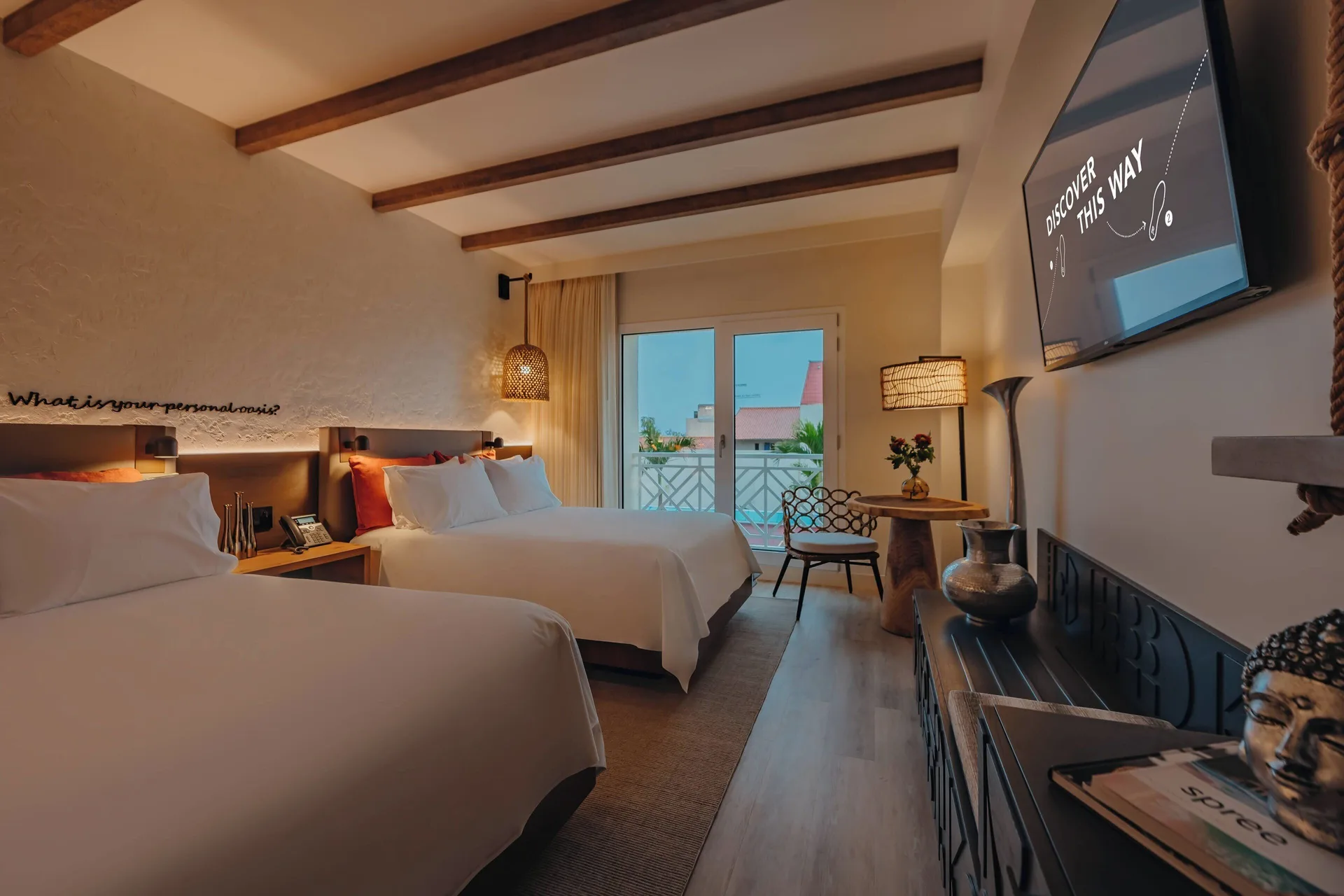 Two-bed guest room with balcony doors at Renaissance Wind Creek Aruba Resort.