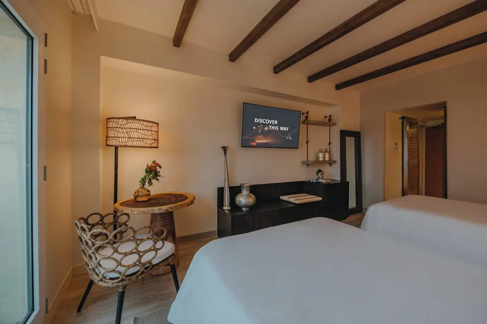 Two-bed guest room with TV and sitting area at Renaissance Wind Creek Aruba Resort.
