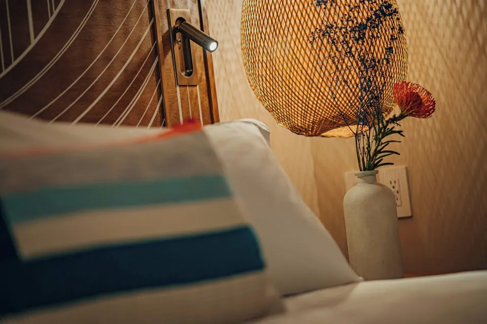 Suite bedside detail with pillow, lamp and vase at Renaissance Wind Creek Aruba Resort.