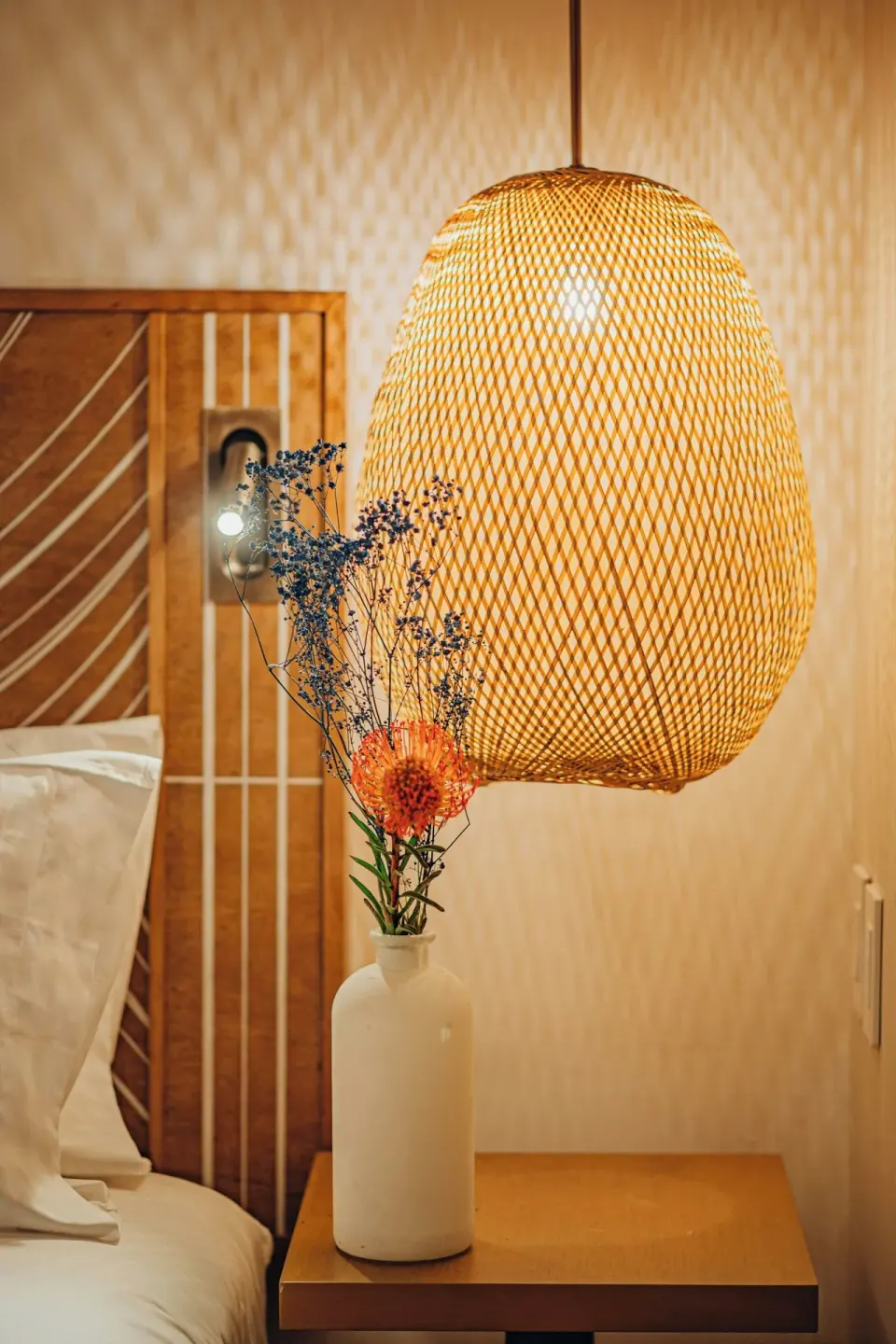 Suite bedside table with woven pendant light at Renaissance Wind Creek Aruba Resort.