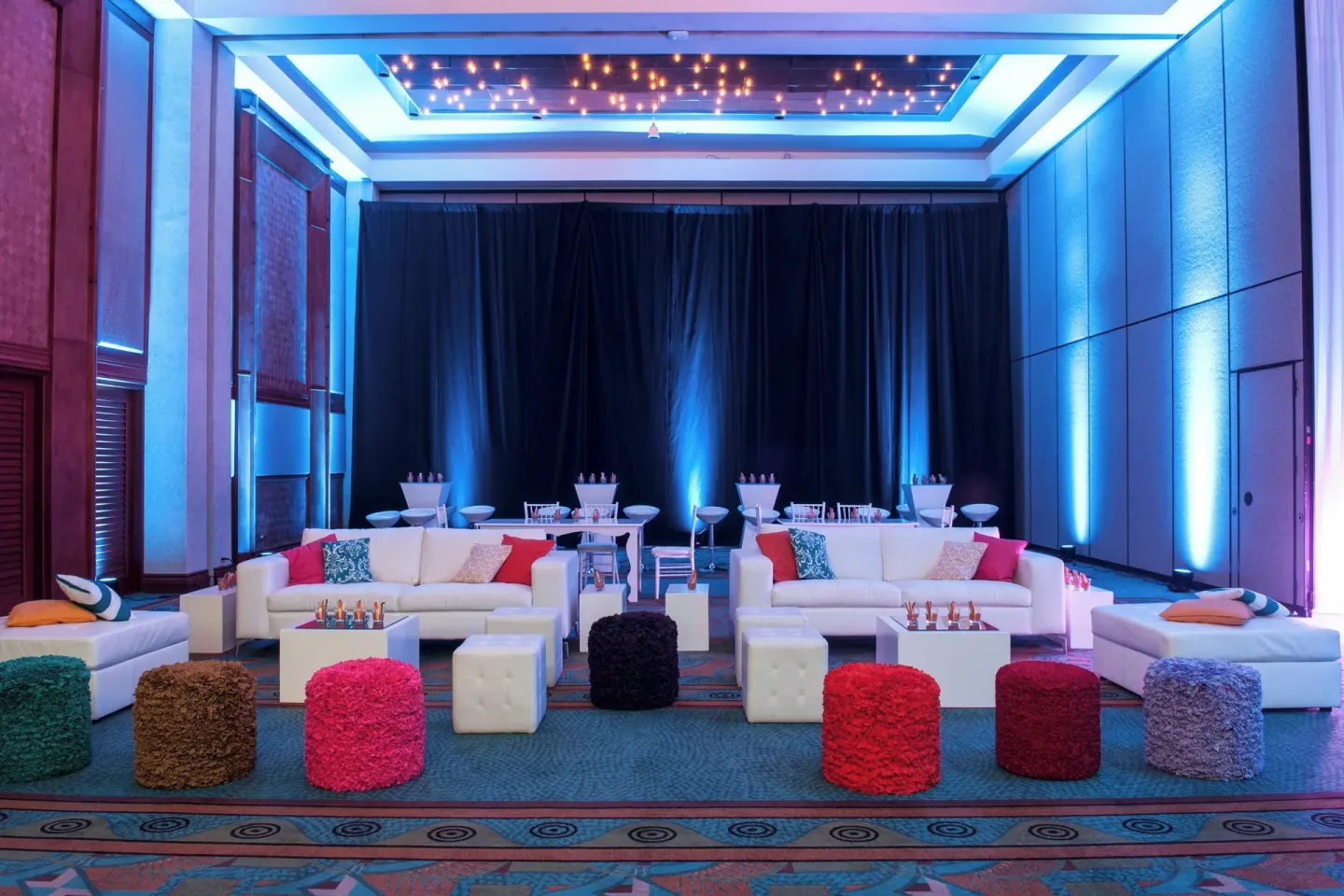 Colorful event lounge setup with sofas and blue lighting at Renaissance Wind Creek Aruba Resort.
