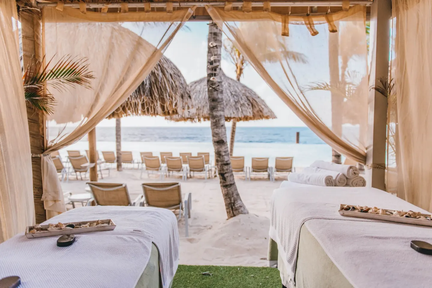 Two beach massage tables inside a cabana at Renaissance Wind Creek Curacao Resort.