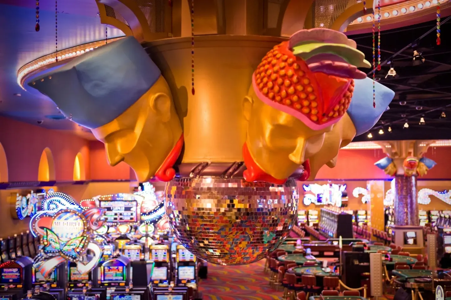 Colorful casino floor decor above slot machines at Renaissance Wind Creek Curacao Resort.