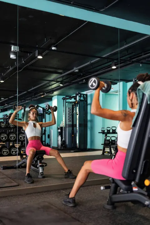 Guest lifting dumbbells in the gym at Renaissance Wind Creek Curacao Resort.