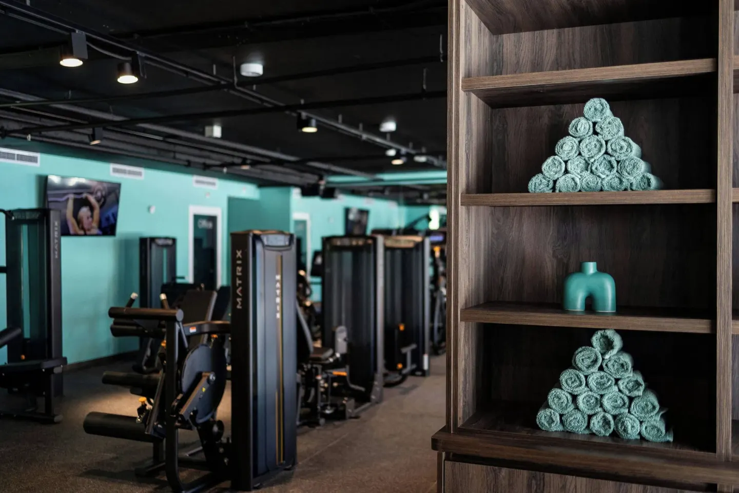 Rolled towels sit on shelving beside fitness machines at Renaissance Wind Creek Curacao Resort.