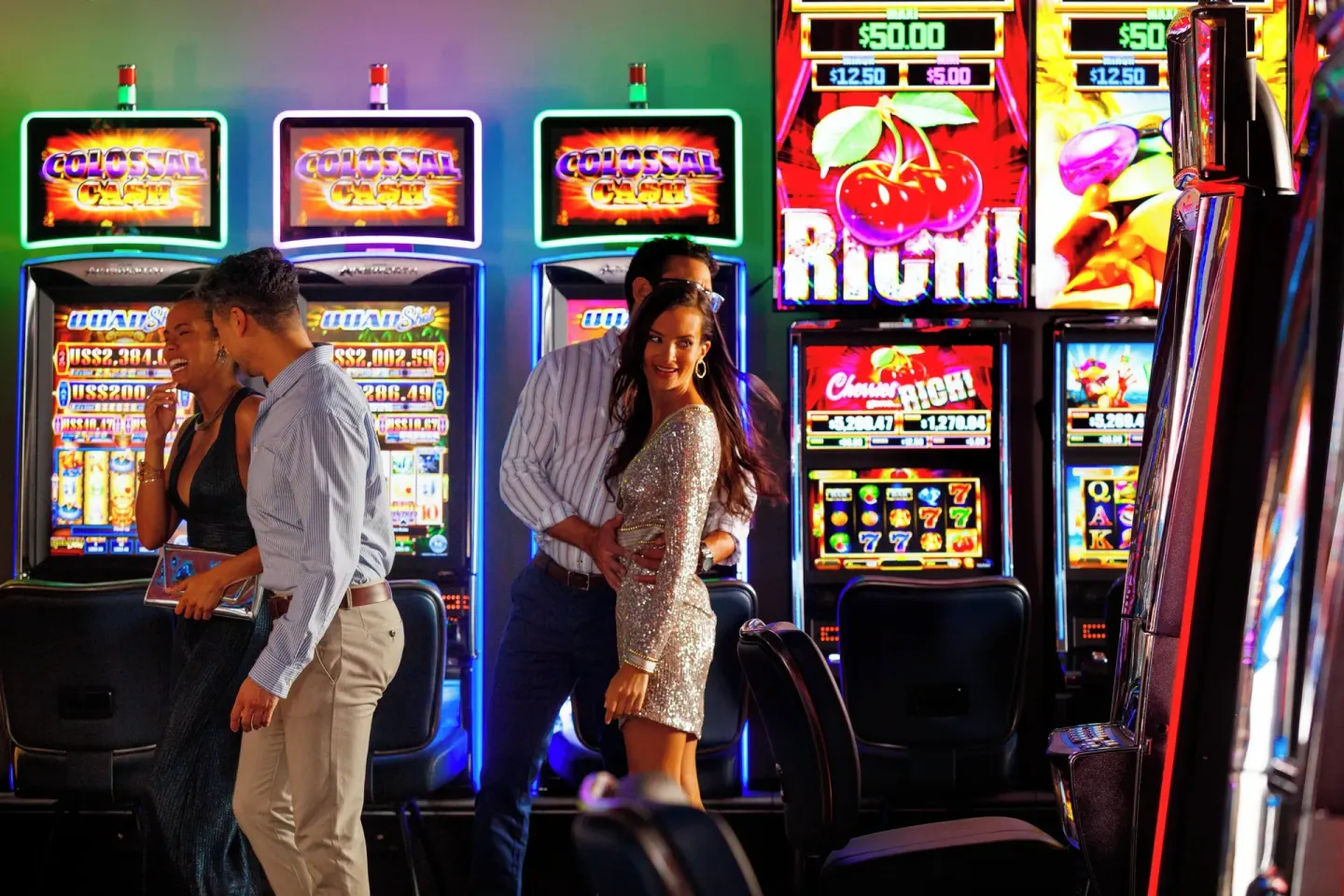 Guests standing near bright slot machines at Renaissance Wind Creek Curacao Resort.