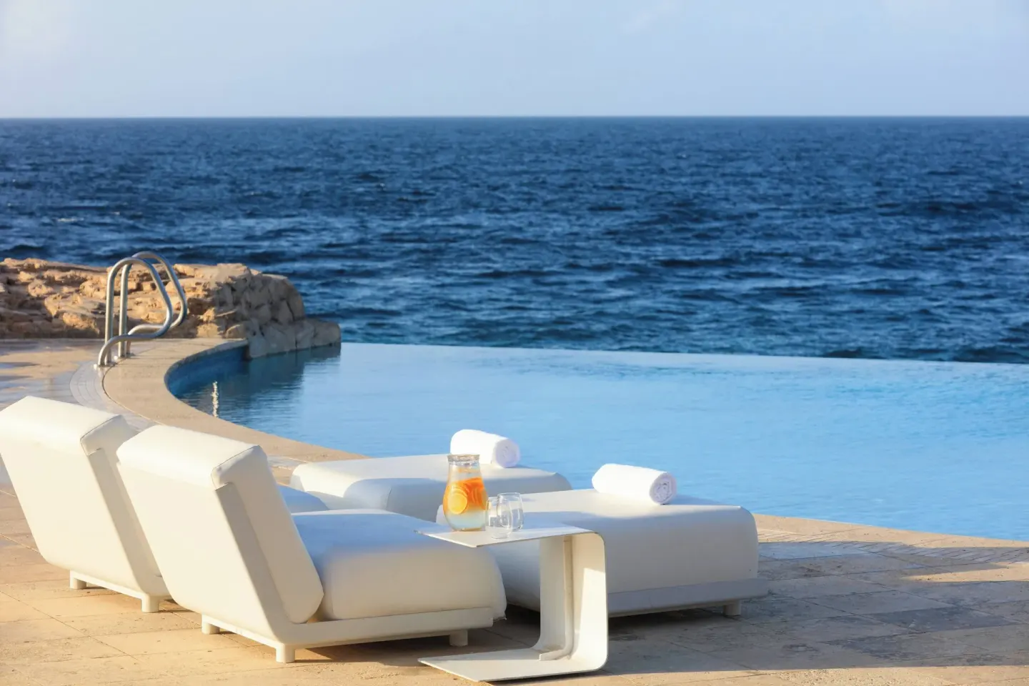Oceanfront pool loungers at Renaissance Wind Creek Curacao Resort.