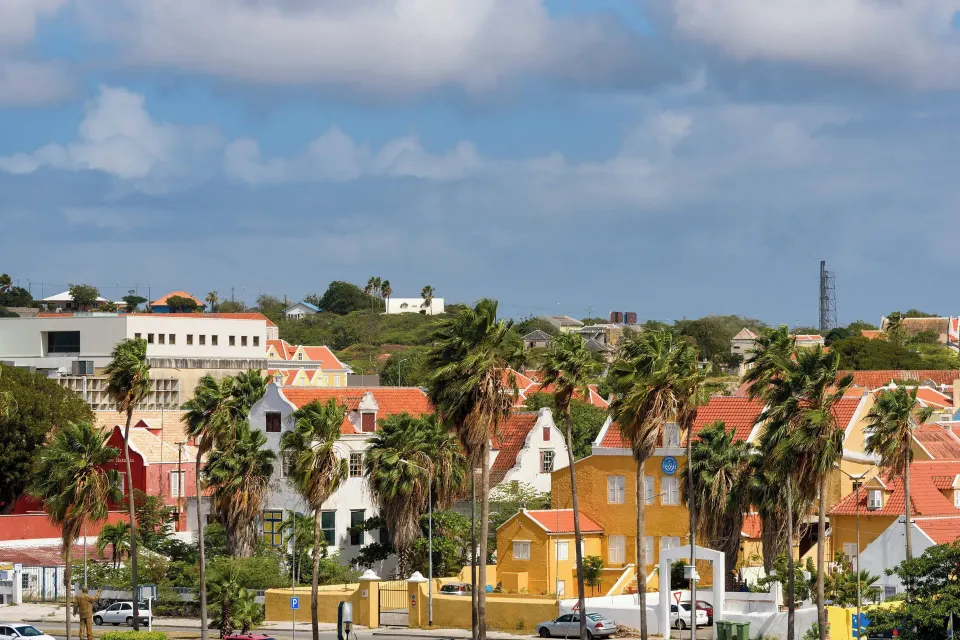 Balcony view of palm trees and colorful city buildings at Renaissance Wind Creek Curacao Resort.