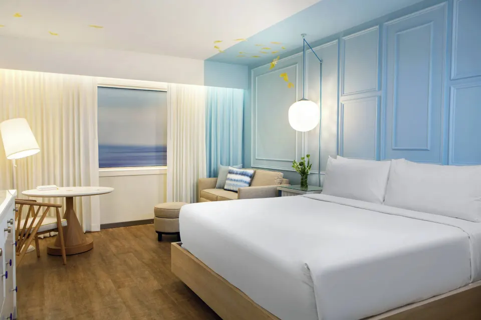 King guest room with sofa and round table at Renaissance Wind Creek Curacao Resort.