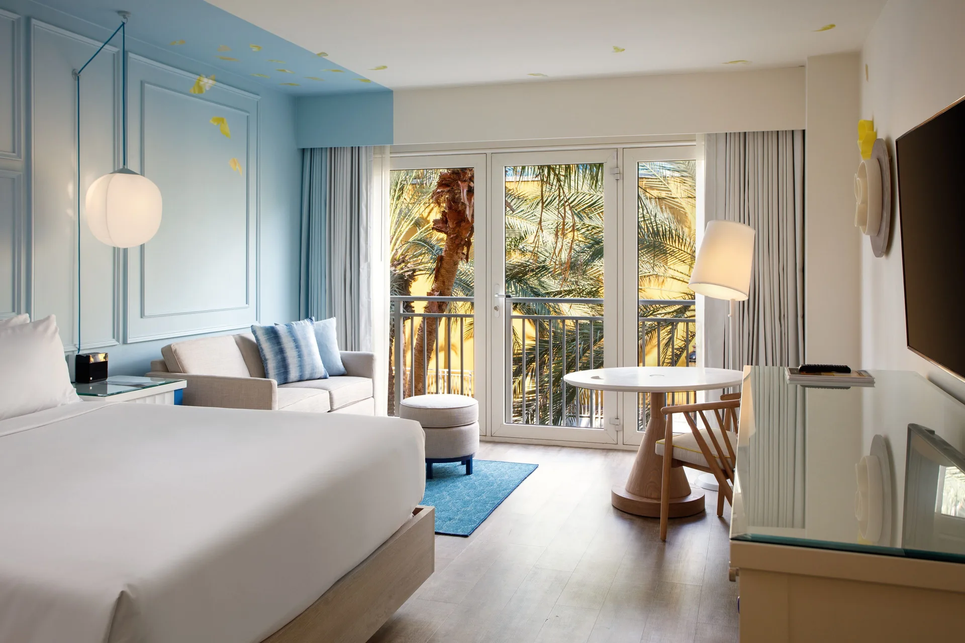 King guest room with sofa and palm view at Renaissance Wind Creek Curacao Resort.