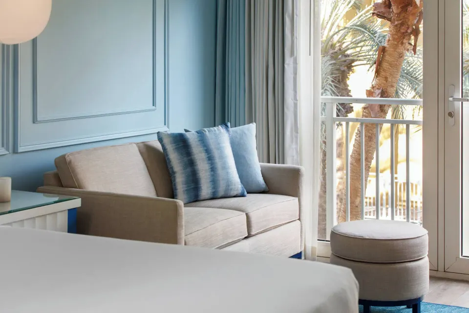 Guest room sofa beside balcony doors at Renaissance Wind Creek Curacao Resort.