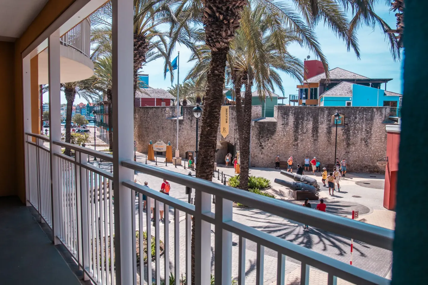 One bedroom suite balcony view of palms and street at Renaissance Wind Creek Curacao Resort.