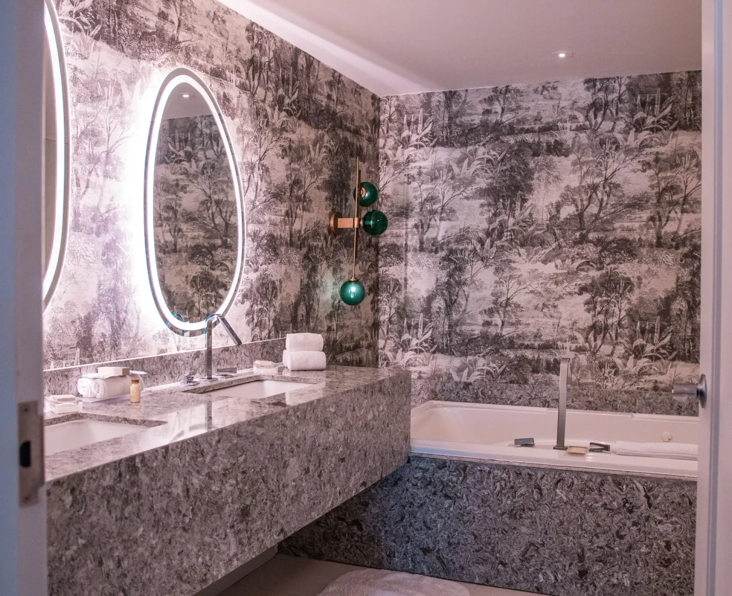 One bedroom suite bathroom with tub, double vanity and round mirrors at Renaissance Wind Creek Curacao Resort.