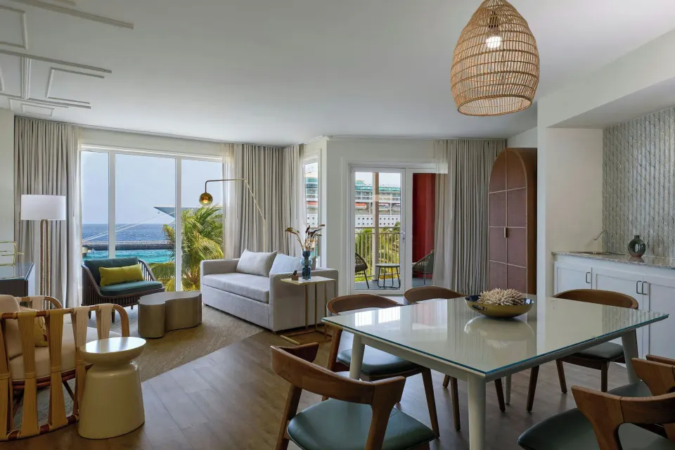 One bedroom suite living and dining area with balcony doors at Renaissance Wind Creek Curacao Resort.