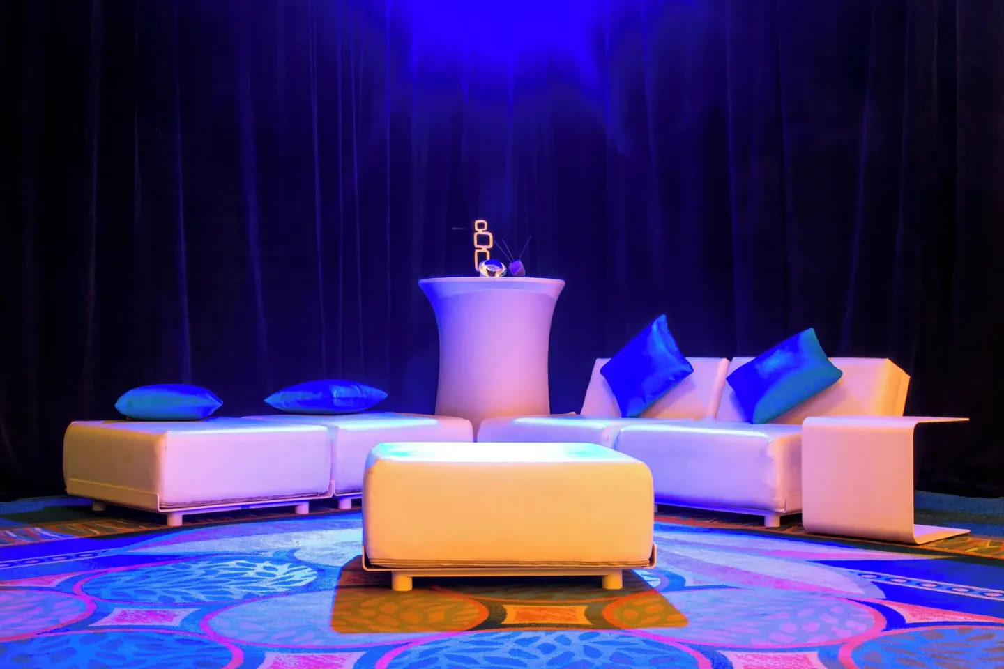 White lounge seating with blue event lighting at Renaissance Wind Creek Curacao Resort.