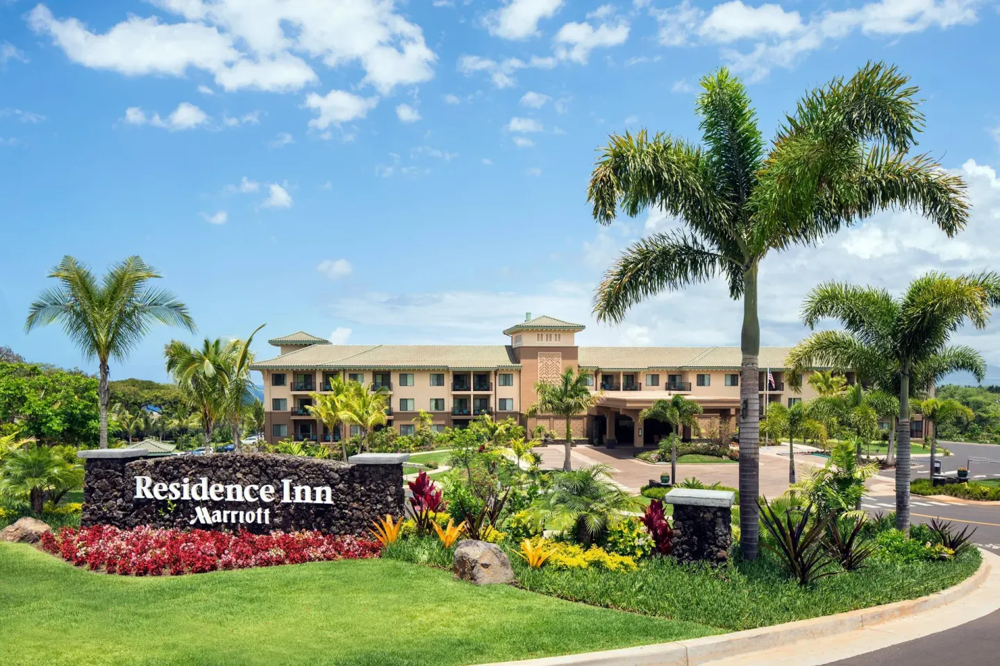 Entrance sign, palms and landscaped driveway at Residence Inn Maui Wailea.