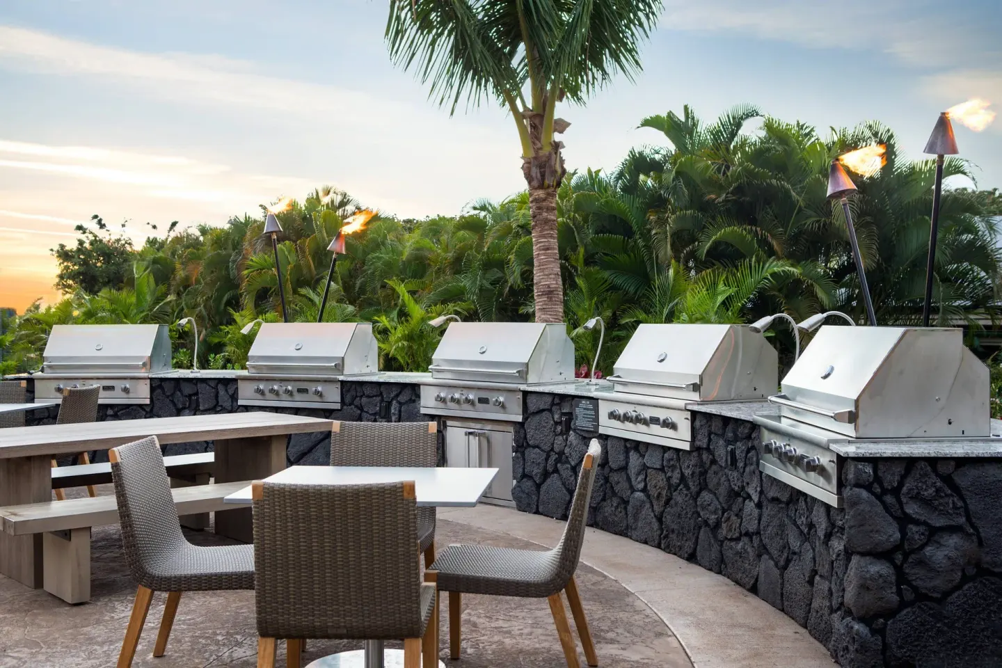 Outdoor barbecue grills, tables and tiki torches at Residence Inn Maui Wailea.