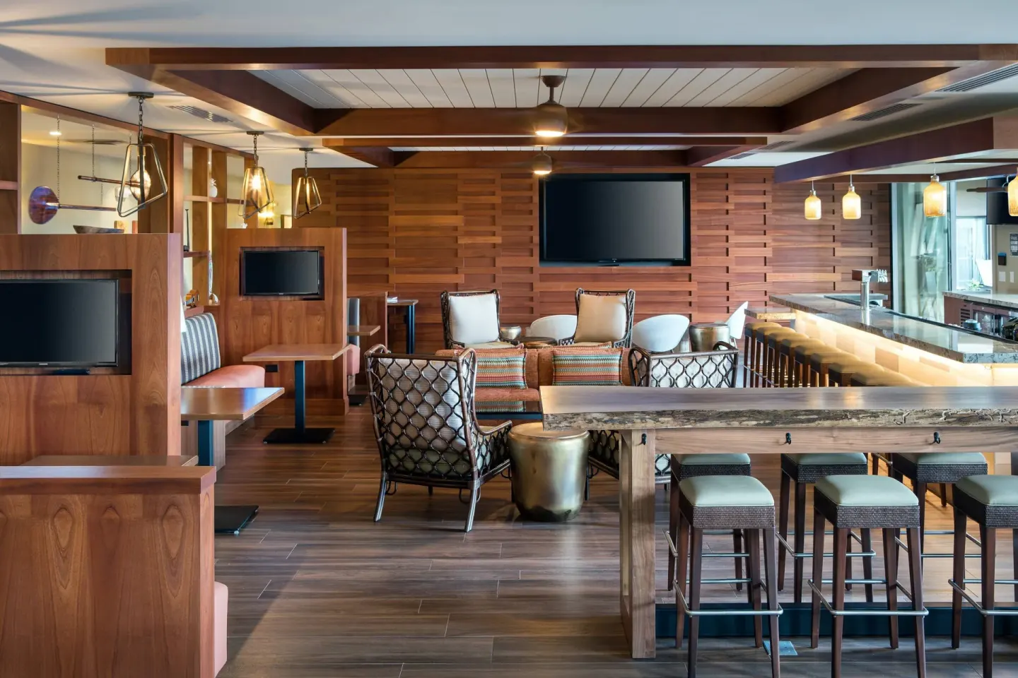 Lounge seating and bar-height tables in a wood-accented space at Residence Inn Maui Wailea.