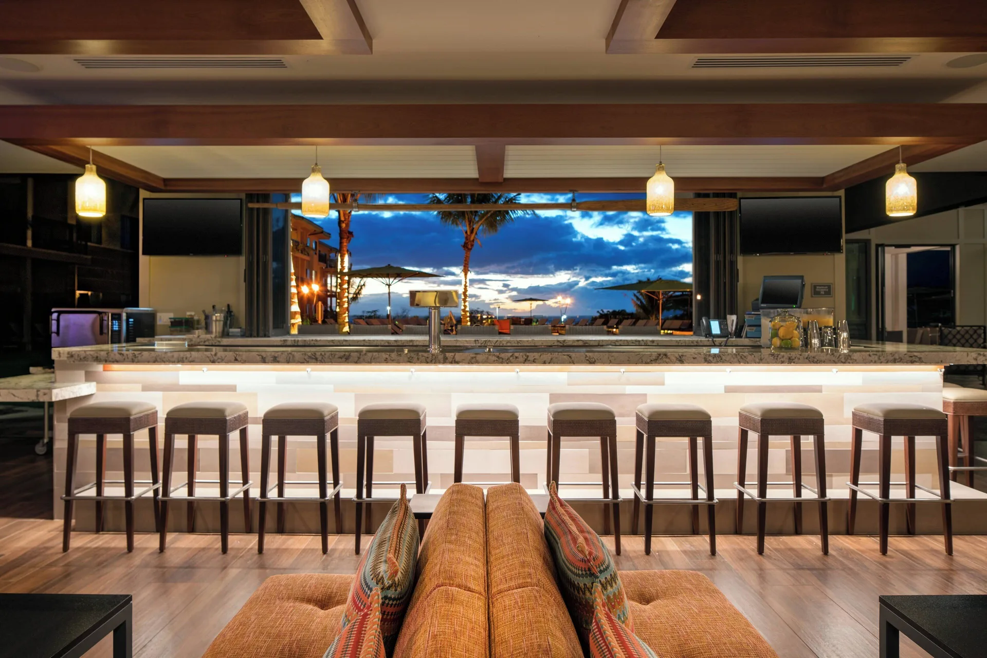 Open-air bar with stools and sunset view at Residence Inn Maui Wailea.