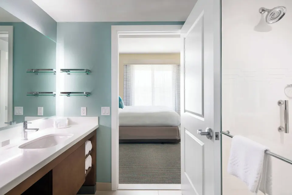 Studio bathroom with vanity and glass shower at Residence Inn Maui Wailea.