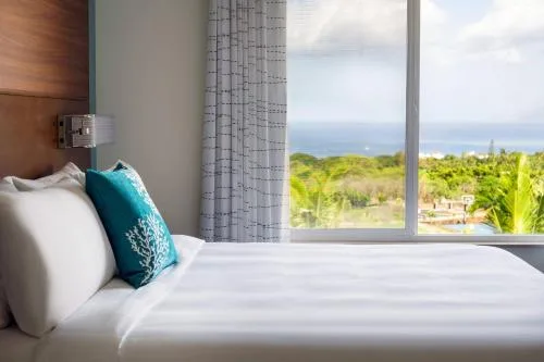 King bed beside a large ocean-facing window at Residence Inn Maui Wailea.