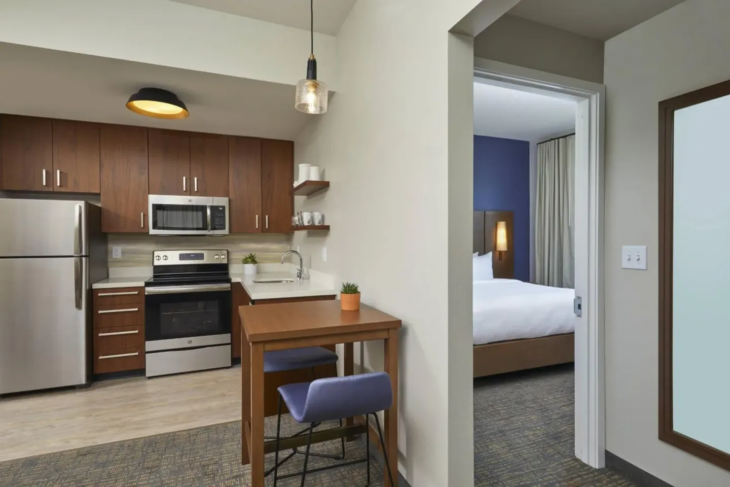 Guest suite kitchen, dining nook, and bedroom doorway at Residence Inn Oahu Kapolei.