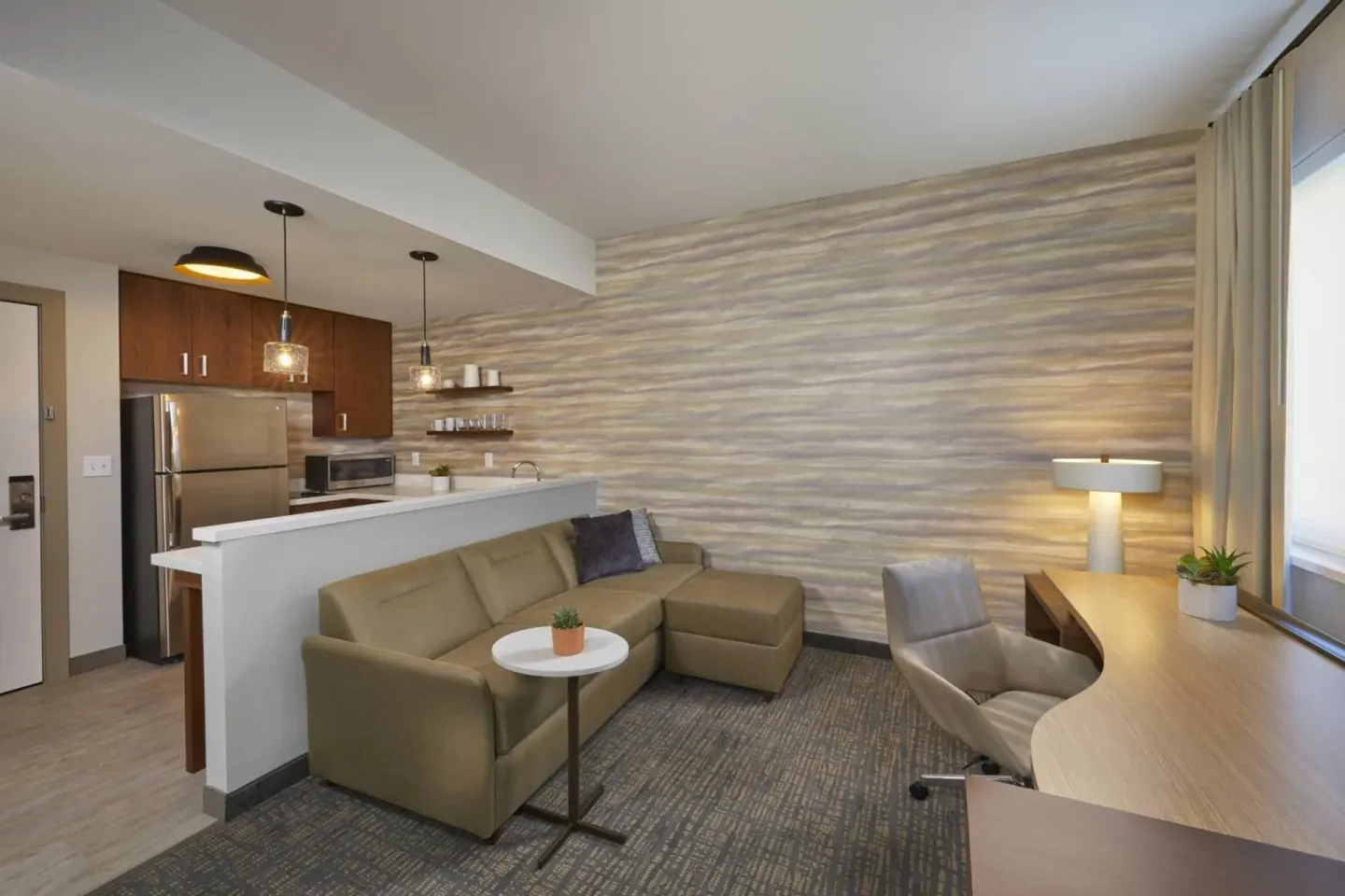 Guest suite living area with kitchenette and desk at Residence Inn Oahu Kapolei.
