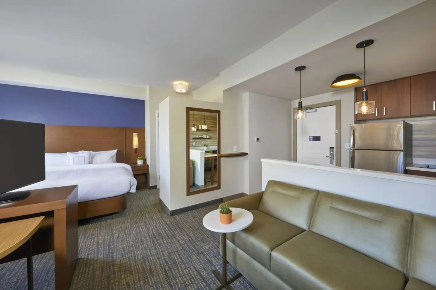 Studio suite with king bed, sofa, kitchenette, and TV at Residence Inn Oahu Kapolei.