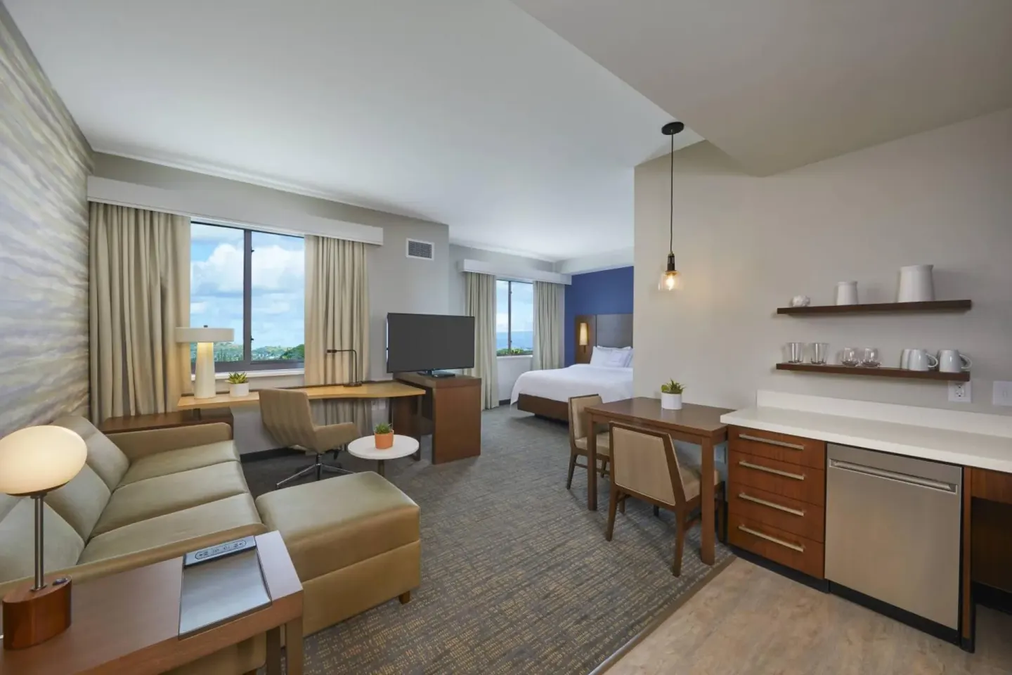 Studio suite with sofa, king bed, work desk, dining table, and kitchenette at Residence Inn Oahu Kapolei.