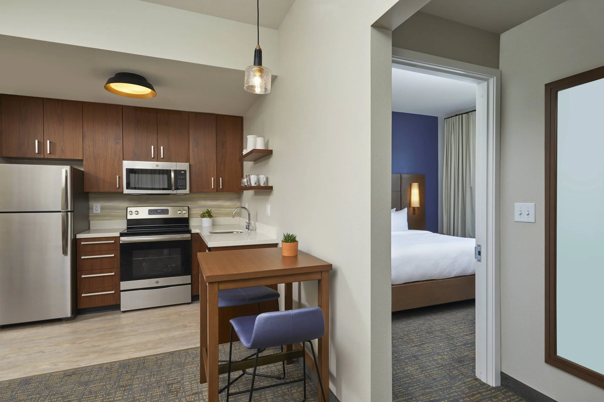 One-bedroom suite kitchen and bedroom doorway at Residence Inn Oahu Kapolei.