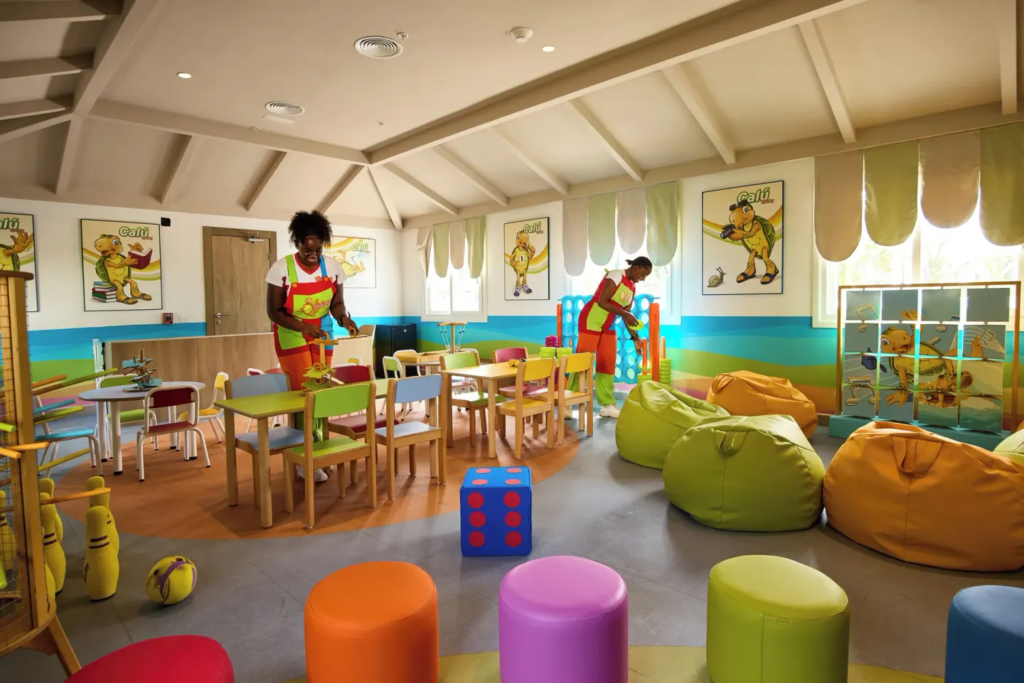 Children's club playroom with small tables, beanbags, toys and staff at Riu Negril.