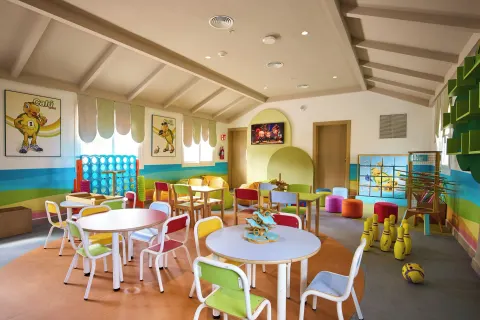 Children's playroom with colorful tables, chairs, games and wall art at Riu Negril.