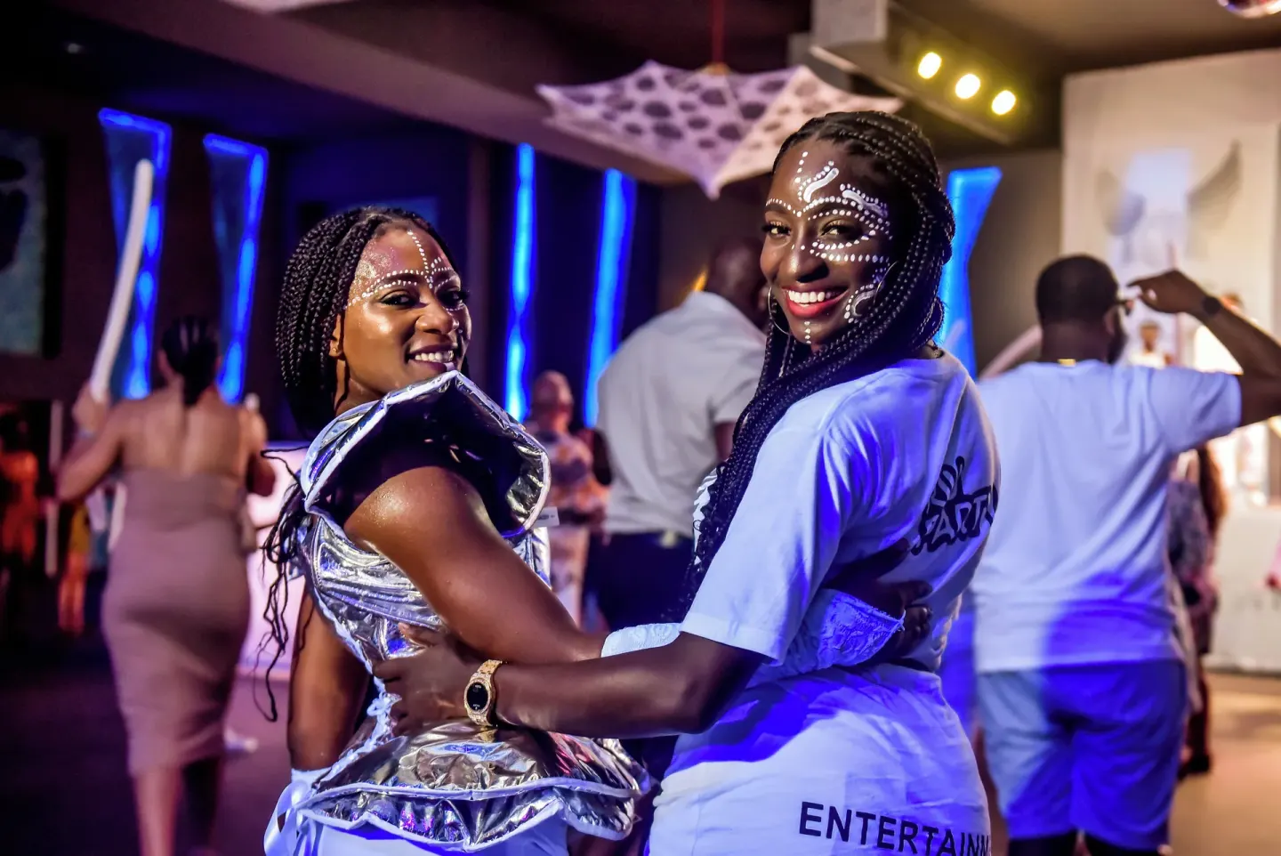 Costumed entertainers smile in a nightclub-style party scene at Riu Negril.