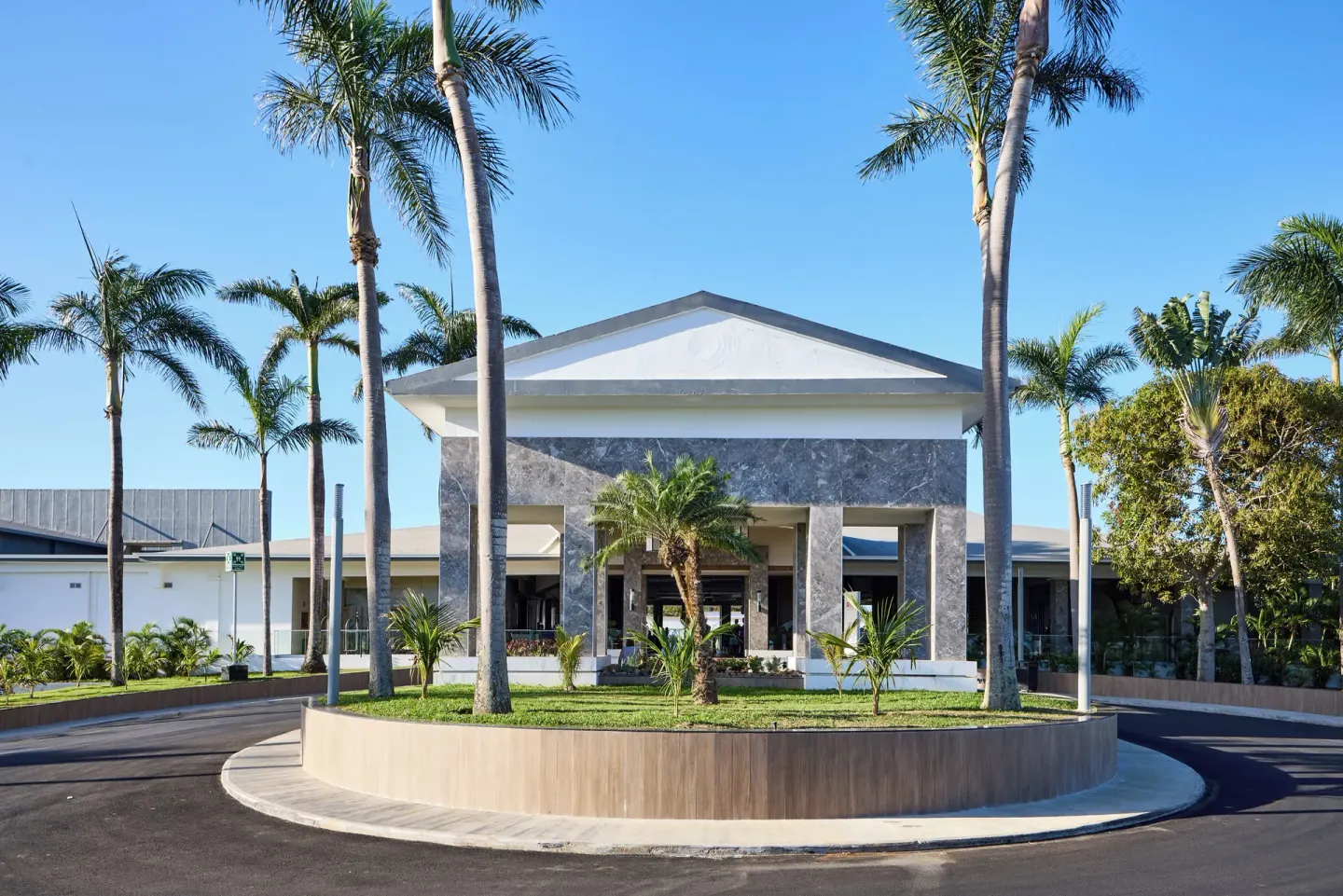 Front entrance building with palms and circular driveway at Riu Negril.