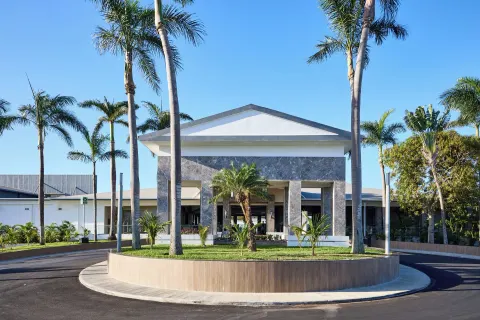 Front entrance building with palms and circular driveway at Riu Negril.