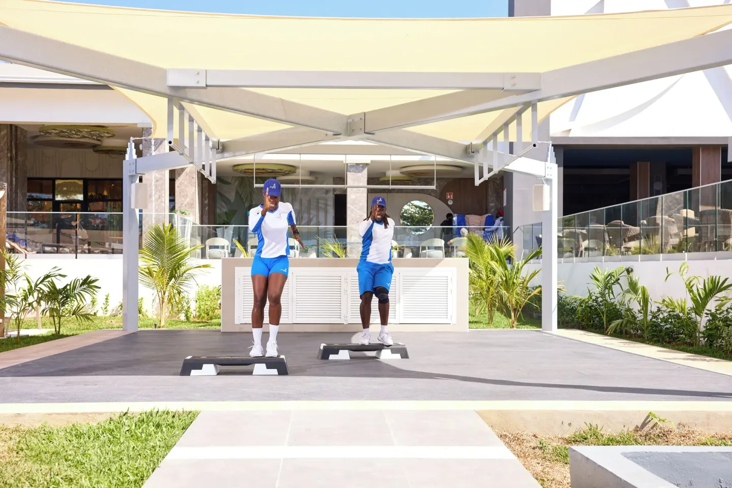 Two instructors lead a step exercise session under a canopy at Riu Negril.