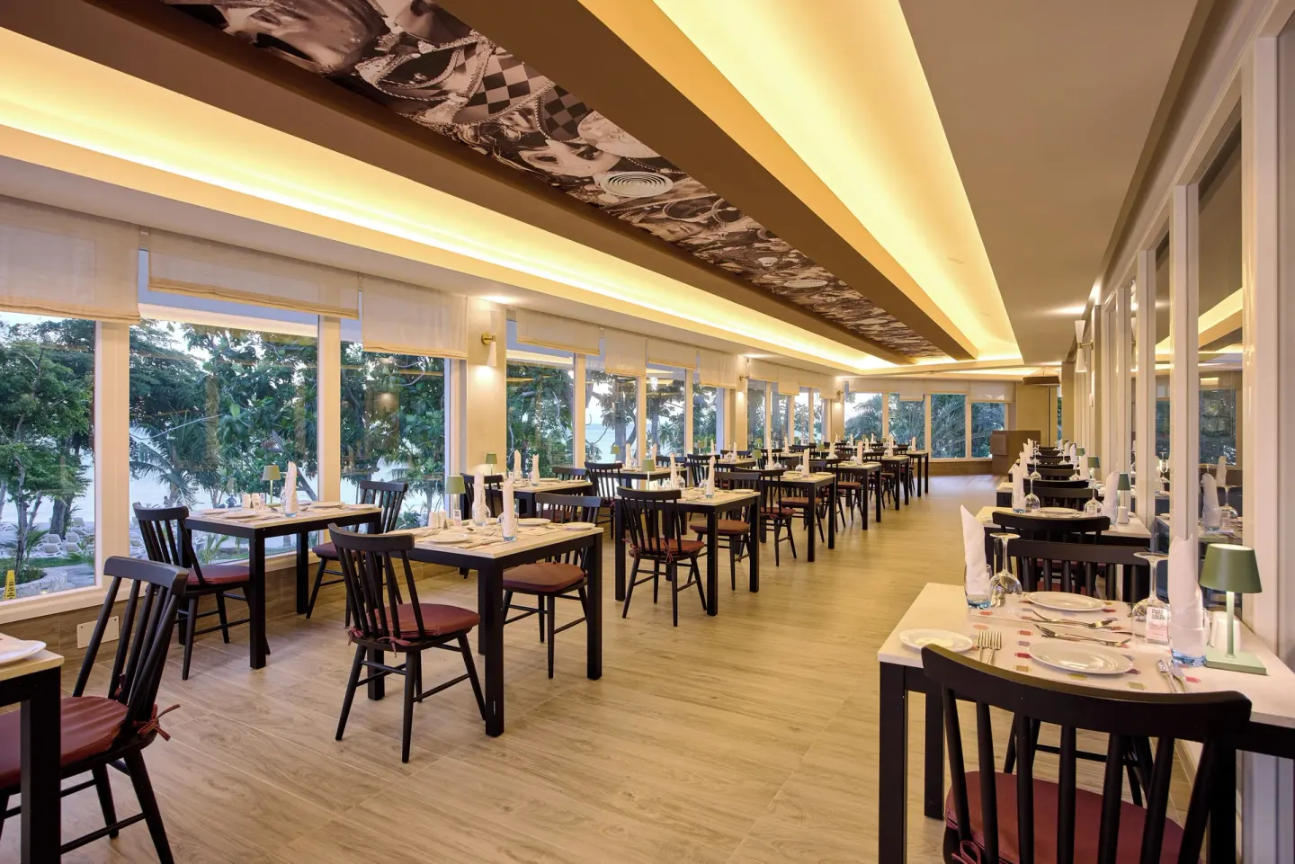 Long dining room with window tables and beach views at Riu Negril.